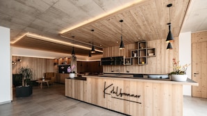 A modern kitchen with wooden cabinetry, a central island, pendant lighting, and a visible name sign.