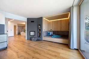 Un interior moderno con un banco de madera, paredes grises y un ventanal grande.