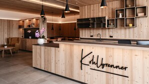 A modern kitchen with wooden cabinetry, pendant lighting, and a central island with the name 'Kohlgronner' on it. - ‘Lodge Melisse’ holiday flat with mountain views, private terrace and private sauna (Mölten)