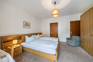 Una camera da letto con un letto in legno, un comodino con una lampada, una sedia e un armadio.