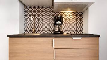 Una cucina con una macchina da caffè, un lavello e uno schienale decorato.