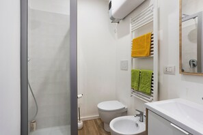 A bathroom with a shower, toilet, sink, and towel rack. - Apartment 'Porta Venezia Small House' with Wi-Fi and Air Conditioning (milano)