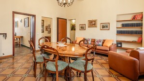 A dining area with a wooden table and chairs, a sofa, and a bookshelf. - Holiday Home 'Bellavista Altopascio' with Private Terrace and Wi-Fi (Altopascio)