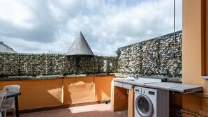 A rooftop with a washing machine, a table, and chairs. - Holiday Home 'Bellavista Altopascio' with Private Terrace and Wi-Fi (Altopascio)