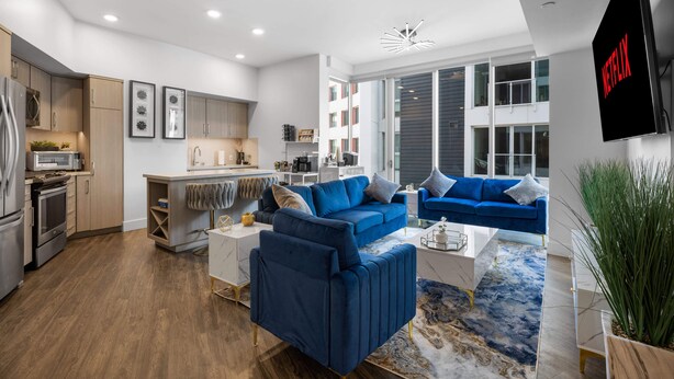 A modern apartment with a kitchen, living area, and a large window.