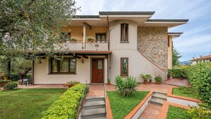 Une maison à deux étages avec une façade en pierre, une porte en bois et un petit balcon.