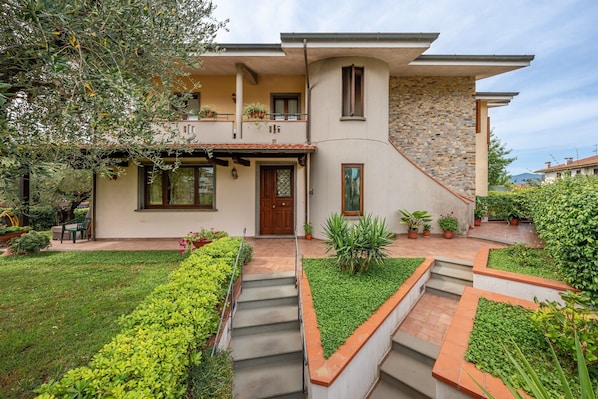Une maison à deux étages avec une façade en pierre, une porte en bois et un petit balcon.