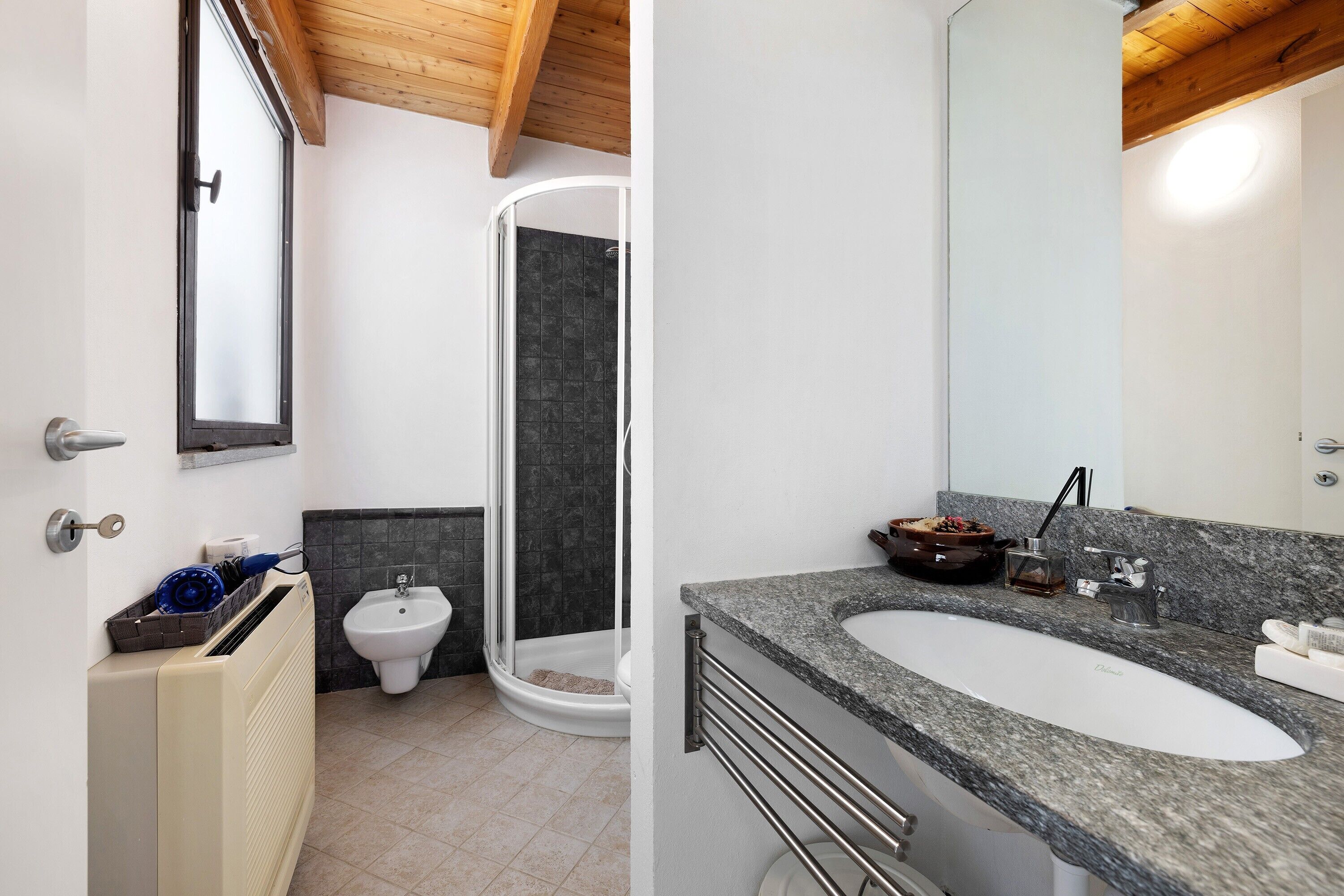 Ein Badezimmer mit Dusche, Bidet und Waschbecken inklusive Spiegel.