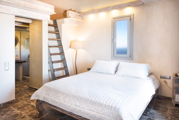 A bedroom with a bed, a ladder, a lamp, a window, and a nightstand.