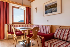 Un coin repas avec une table en bois, des chaises et un banc.