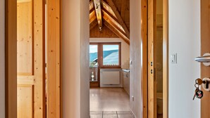 Pasillo interior de madera que conduce a un baño con vistas a las montañas.