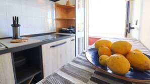 Een keuken met een aanrecht, een bord met citroenen en een raam met uitzicht.