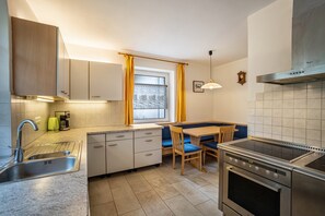 Une cuisine de taille réduite comprenant un évier, une cuisinière et un coin repas.