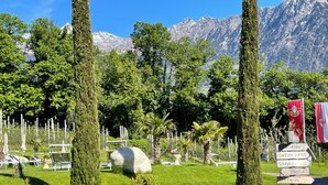 A garden with a check-in sign, lounge chairs, and a mountain backdrop. - Apartment 'Faselehof  Amelia' with Mountain View, Shared Pool and Wi-Fi (Marlengo)
