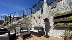 An outdoor patio with stone walls, a metal railing, and outdoor furniture. - YourHouse A Casa Da Corona, beautiful country house (Ourense)