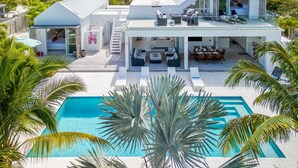 Une maison moderne dotée d’une piscine, d’un espace salon extérieur et d’un grand balcon.