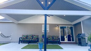 A covered porch with a bench and a grill. - Gem of Jacksonville, near NC Beaches & Military Base (Jacksonville)