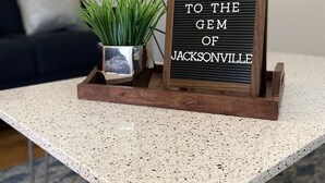 A welcome sign on a table with a plant and a lamp in the background. - Gem of Jacksonville, near NC Beaches & Military Base (Jacksonville)