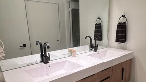 A bathroom with a white sink, a mirror, and wooden cabinets.