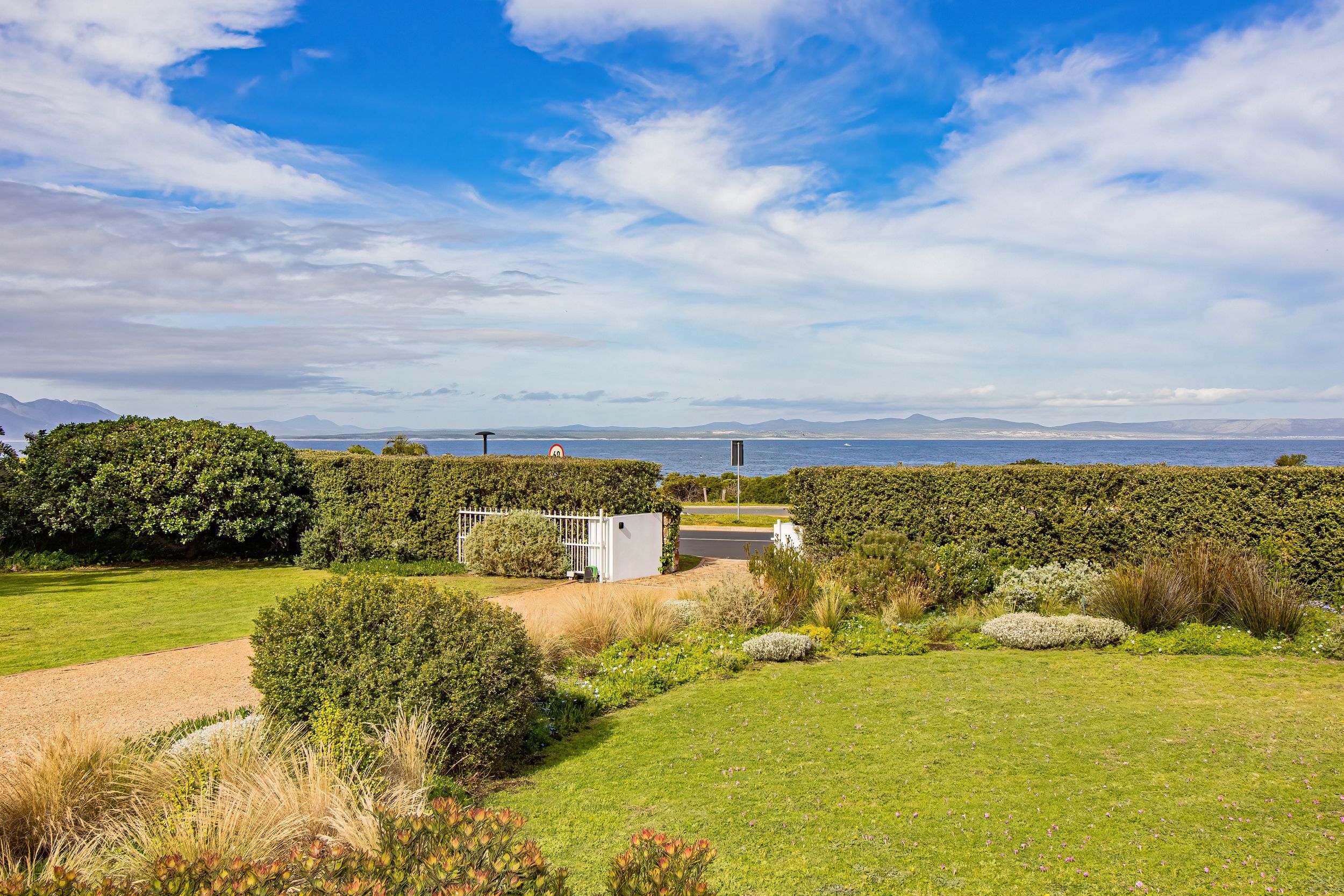 Un espace aménagé offrant une vue dégagée sur la mer et les montagnes lointaines.
