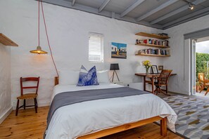 A bedroom with a bed, a desk, a chair, a bookshelf, and a window. - Fairview Hermanus | Ocean View Home, Sleeps 8 (Hermanus)