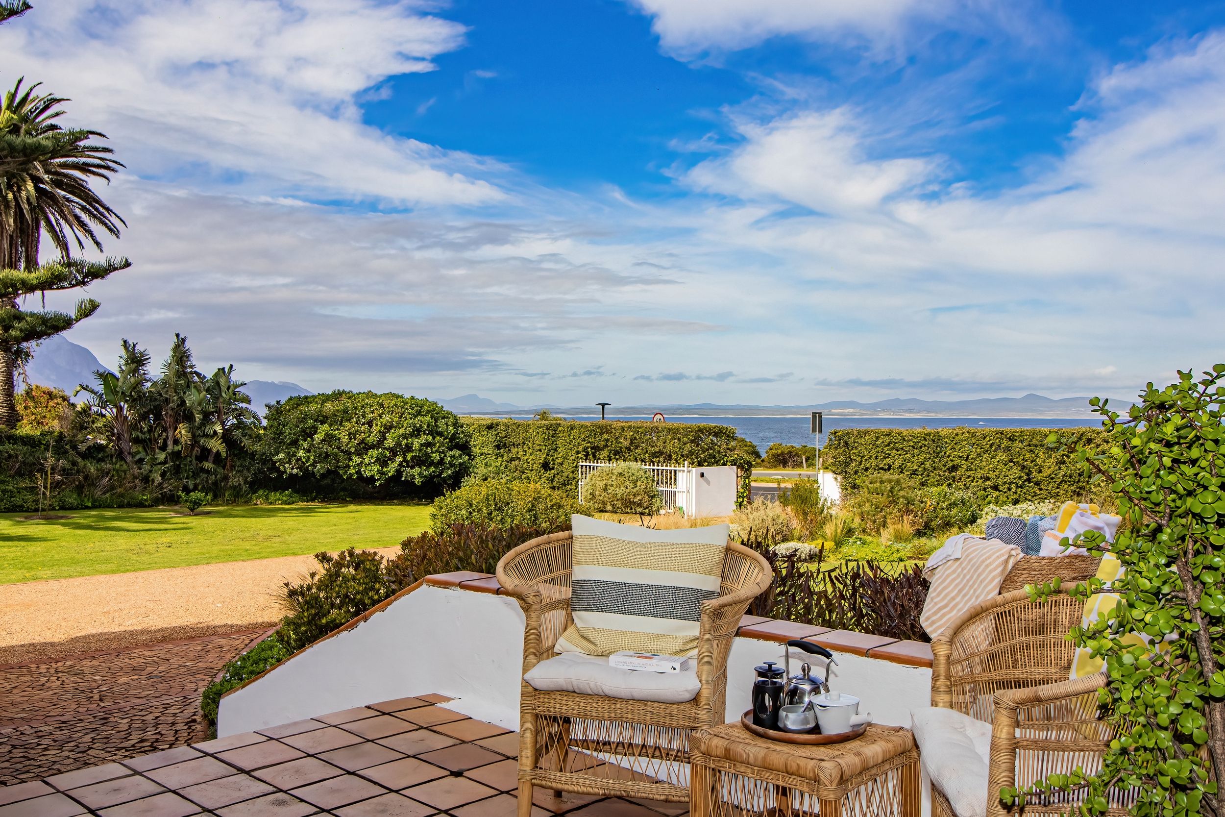 Une terrasse dotée de meubles en osier et offrant une vue sur la mer.