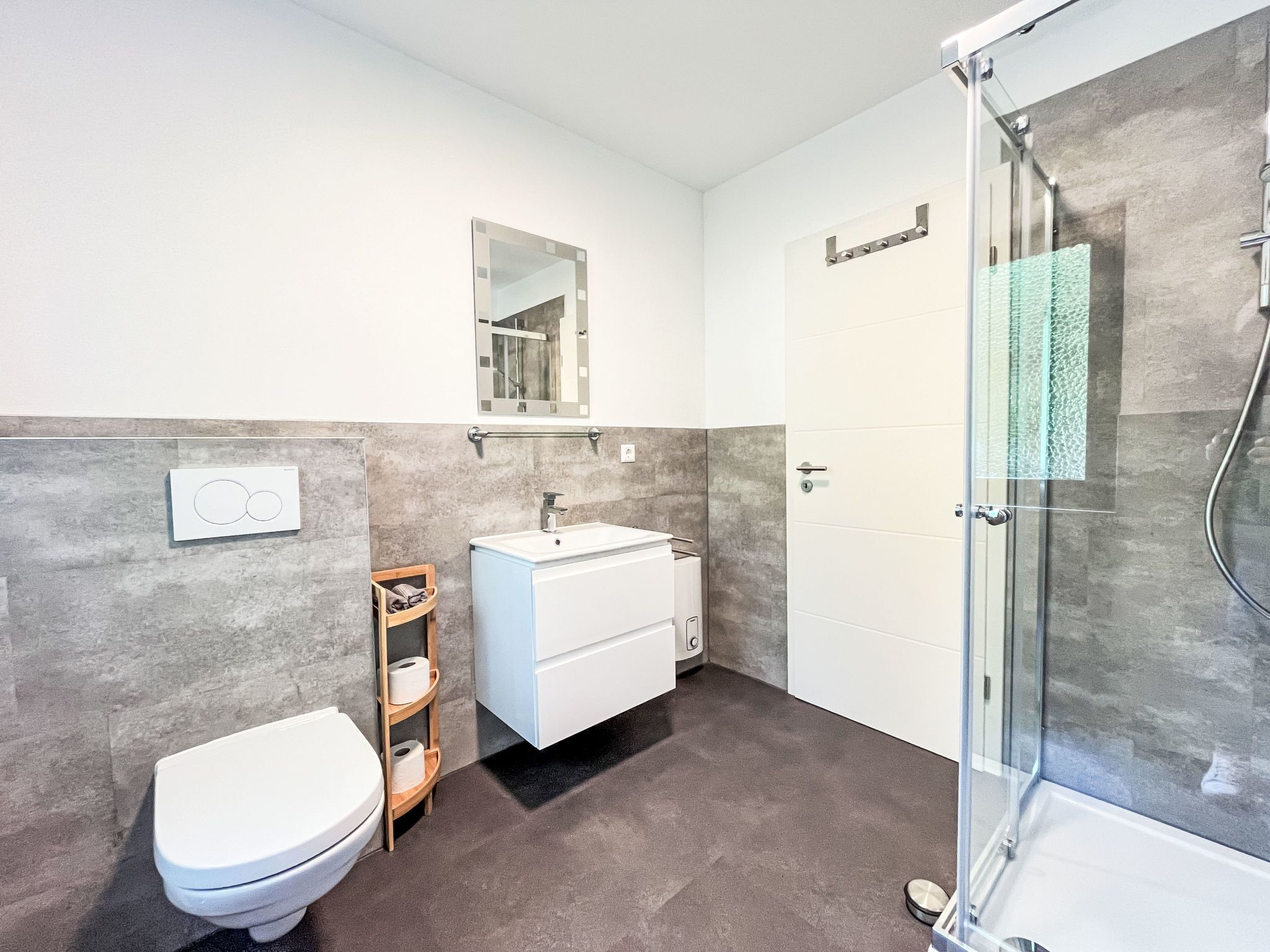 Un baño moderno con inodoro, lavabo y ducha.