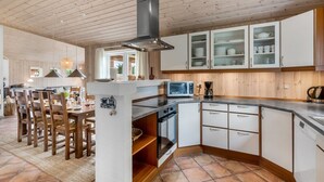 A modern kitchen with white cabinets, a built-in oven, and a microwave.
