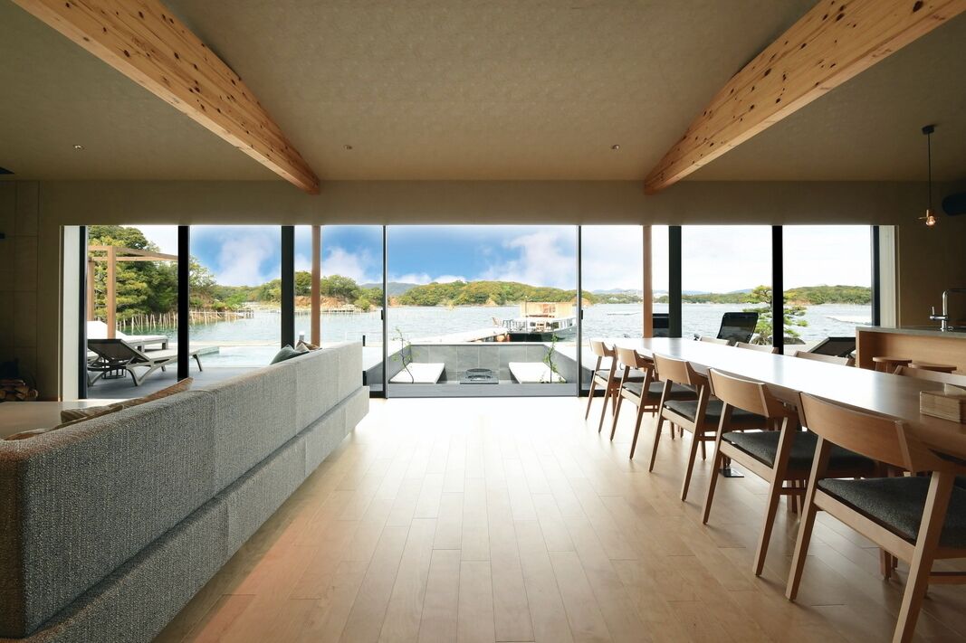 Una cocina moderna con ventanas amplias, un comedor y vistas a un lago.