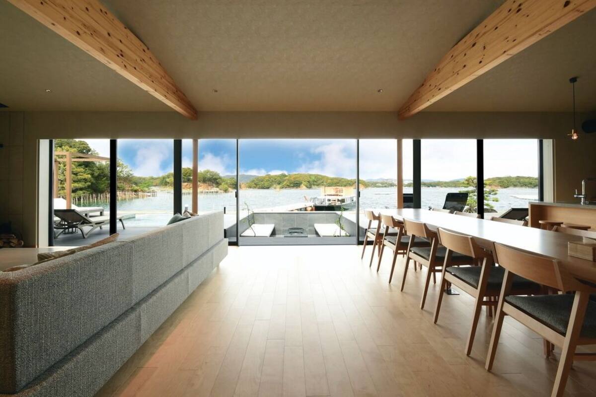 Una cocina moderna con ventanas amplias, un comedor y vistas a un lago.