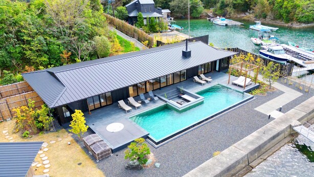 A modern house with a swimming pool, surrounded by boats and greenery. - MOKU ISESHIMA (Shima)