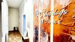Un corridoio con un cartello di benvenuto per AC Holidays.