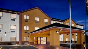 A multi-story hotel with a modern design, featuring a prominent entrance with a covered area and a flagpole. - Quality Inn & Suites McAlester on Hwy 69 (McAlester)