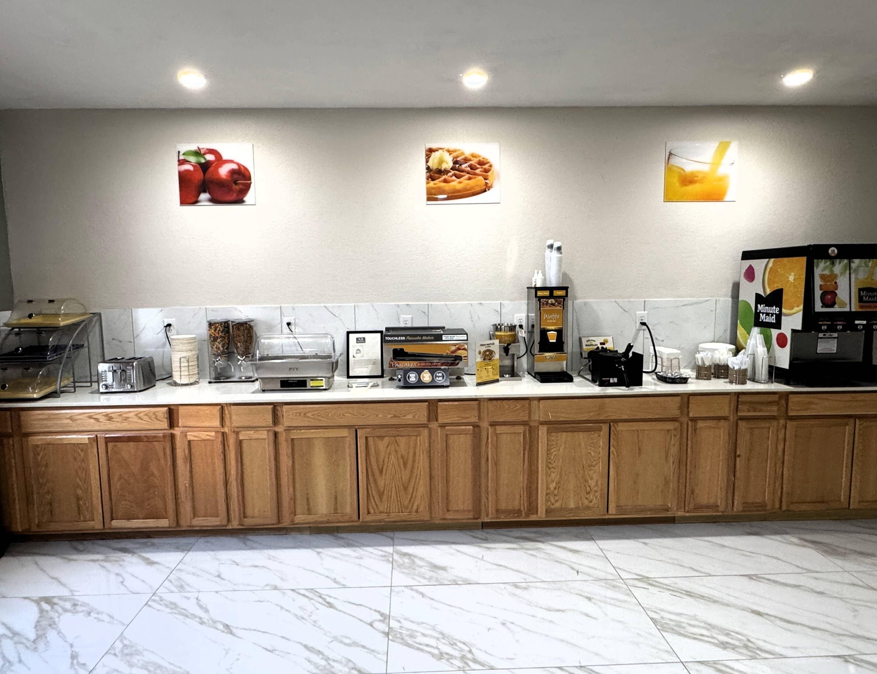 A kitchen with a marble countertop, wooden cabinets, a coffee machine, and a toaster.