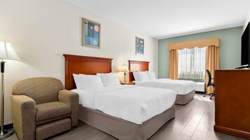 Habitación de hotel con dos camas, una silla, un escritorio y una lámpara.
