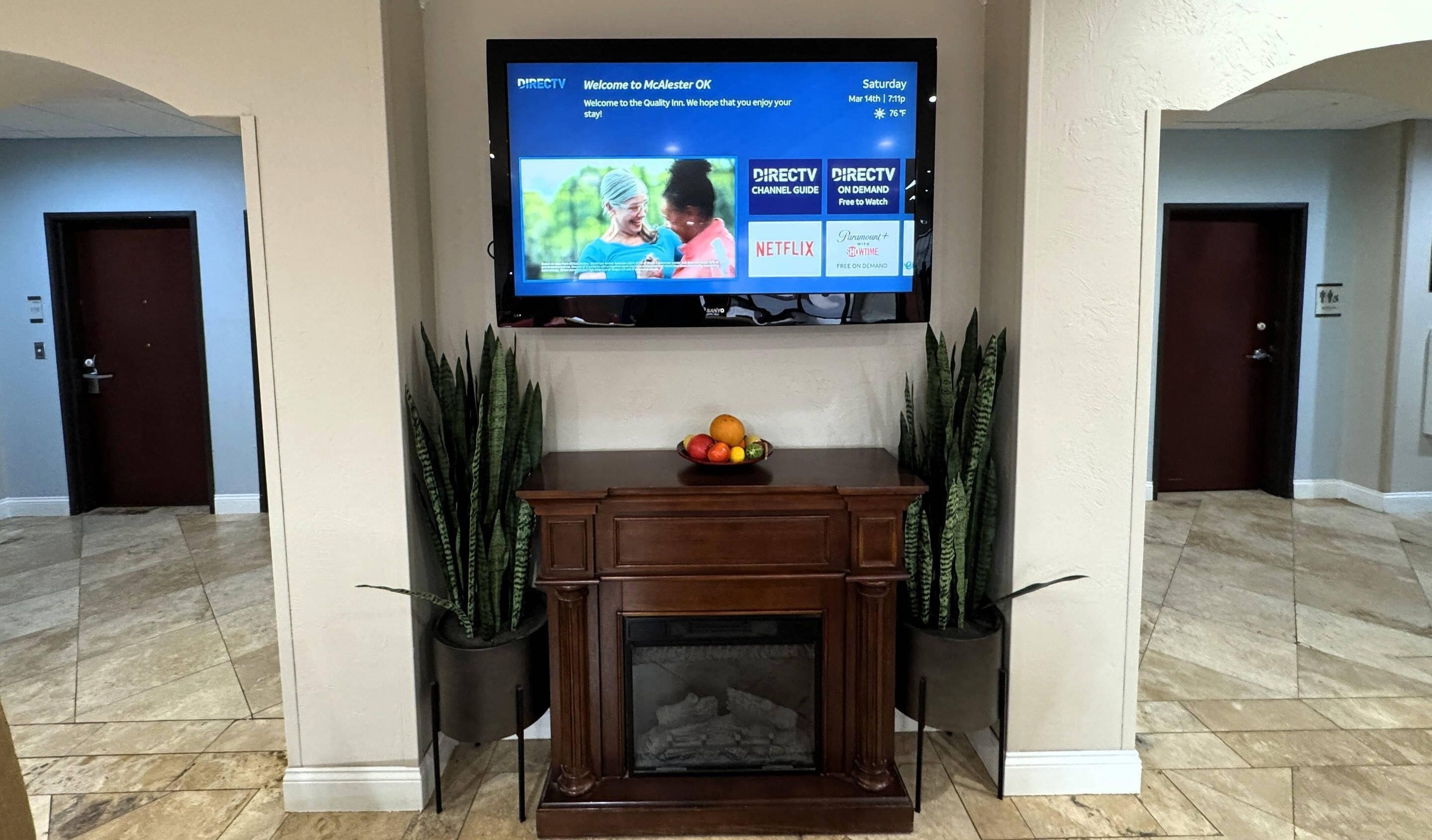 A hotel lobby with a flat-screen TV displaying DIRECTV, Netflix, and Hulu.