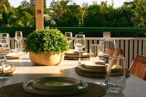 A table set for dining with a potted plant centerpiece, clear glassware, and woven placemats. - Inner-City 6BR Family-friendly House@Highgate Hill (Highgate Hill)