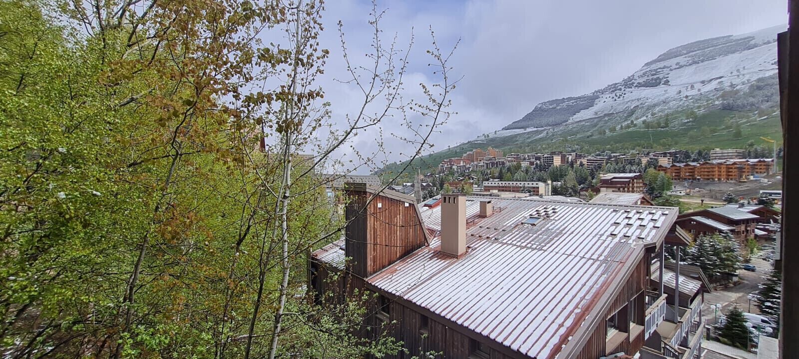 Une ville avec des bâtiments, une montagne et des arbres.