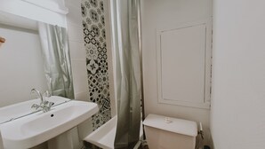 Ein Badezimmer mit Waschbecken, Toilette und Duschvorhang.