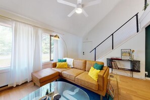 Una sala moderna con un sofá modular, una mesa de centro de vidrio y una estantería.