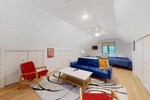 A modern living room with a sofa, a coffee table, and a red chair.