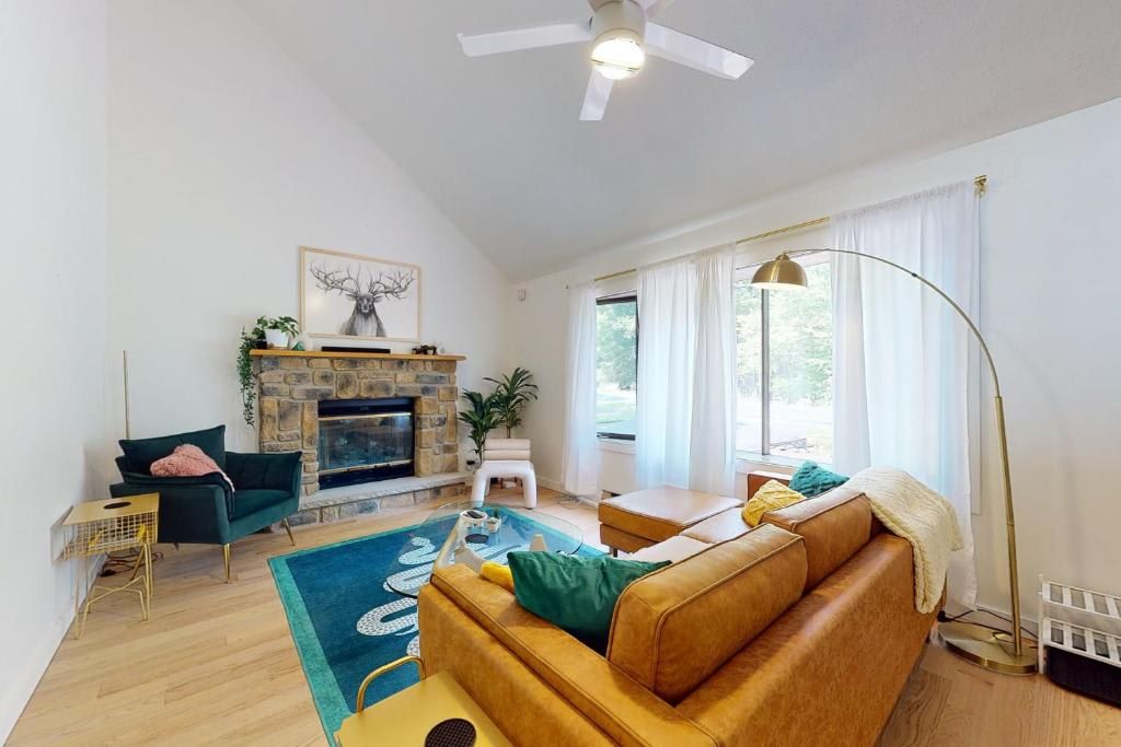 A living room with a fireplace, a sofa, a chair, and a floor lamp.