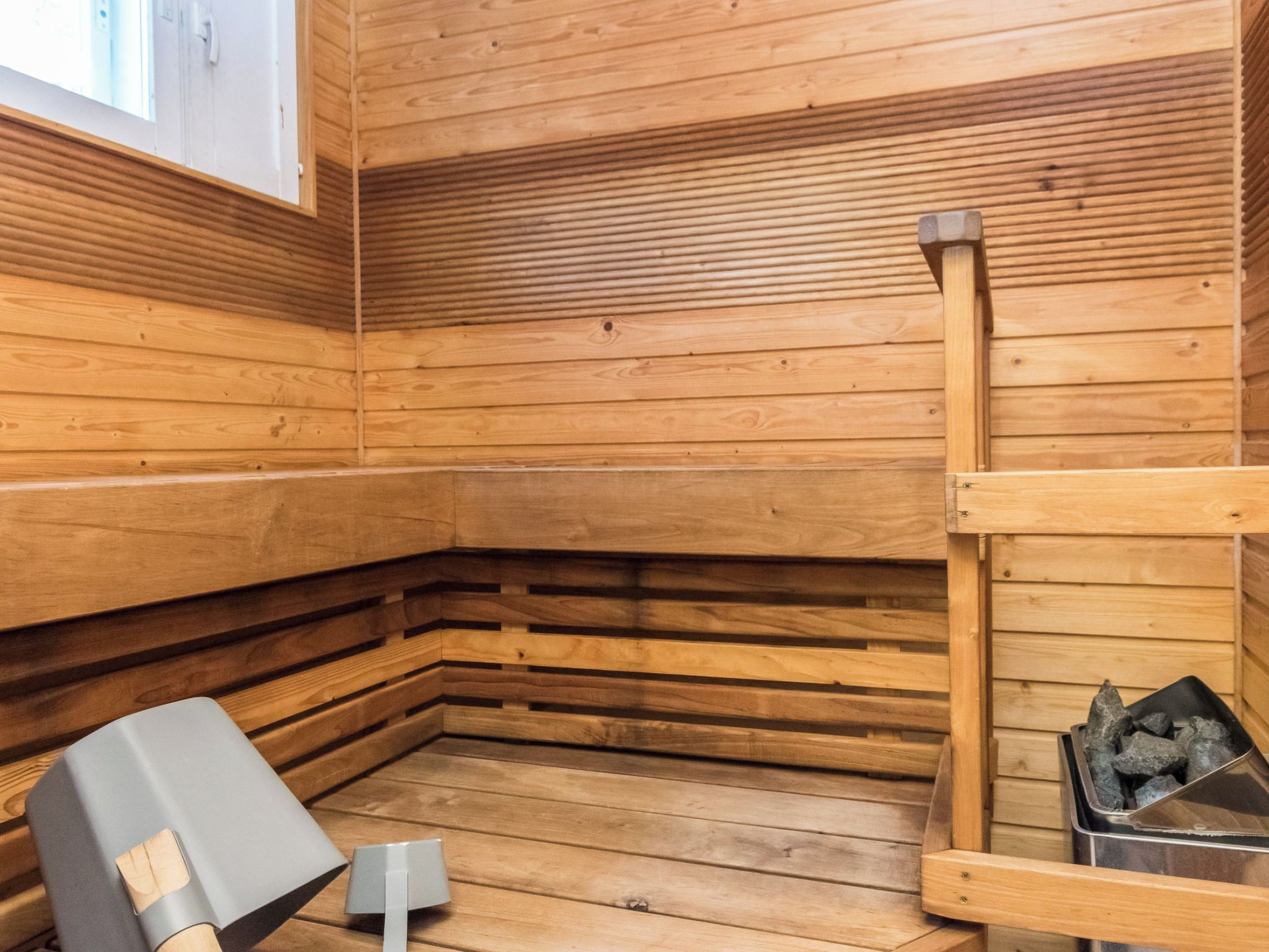 Un sauna avec des murs en bois et un banc.