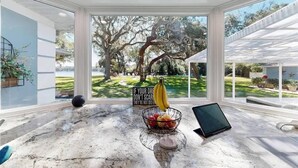 A modern kitchen with a large window, a fruit bowl, and a tablet on the counter. - Luxury Lakeview Home w/ Pool | Perfect for Events (dade city)