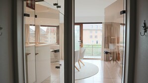 Un apartamento moderno con un ventanal de vidrio que da a un balcón con vistas a edificios.