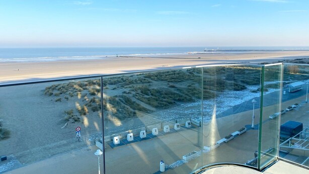 A beach view from a high vantage point, including a sandy beach, dunes, and a pier in the distance. - Apartment in Nieuwpoort near the Beach (Nieuwpoort)