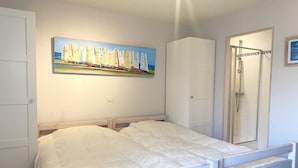 A bedroom with a bed, a wardrobe, and a shower. - Apartment in Nieuwpoort with Sea Views (Nieuwpoort)