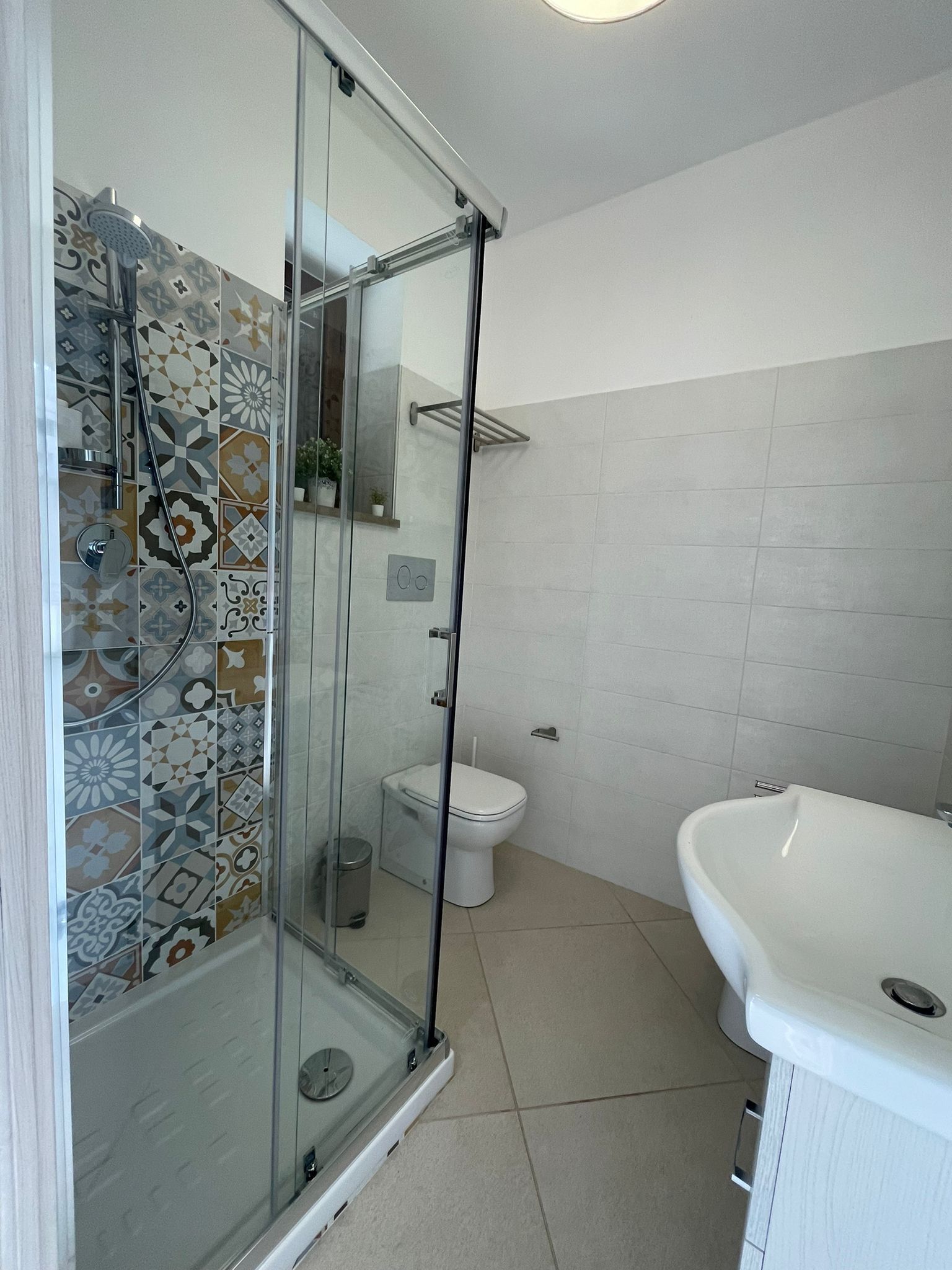 A bathroom with a shower, toilet, and sink.