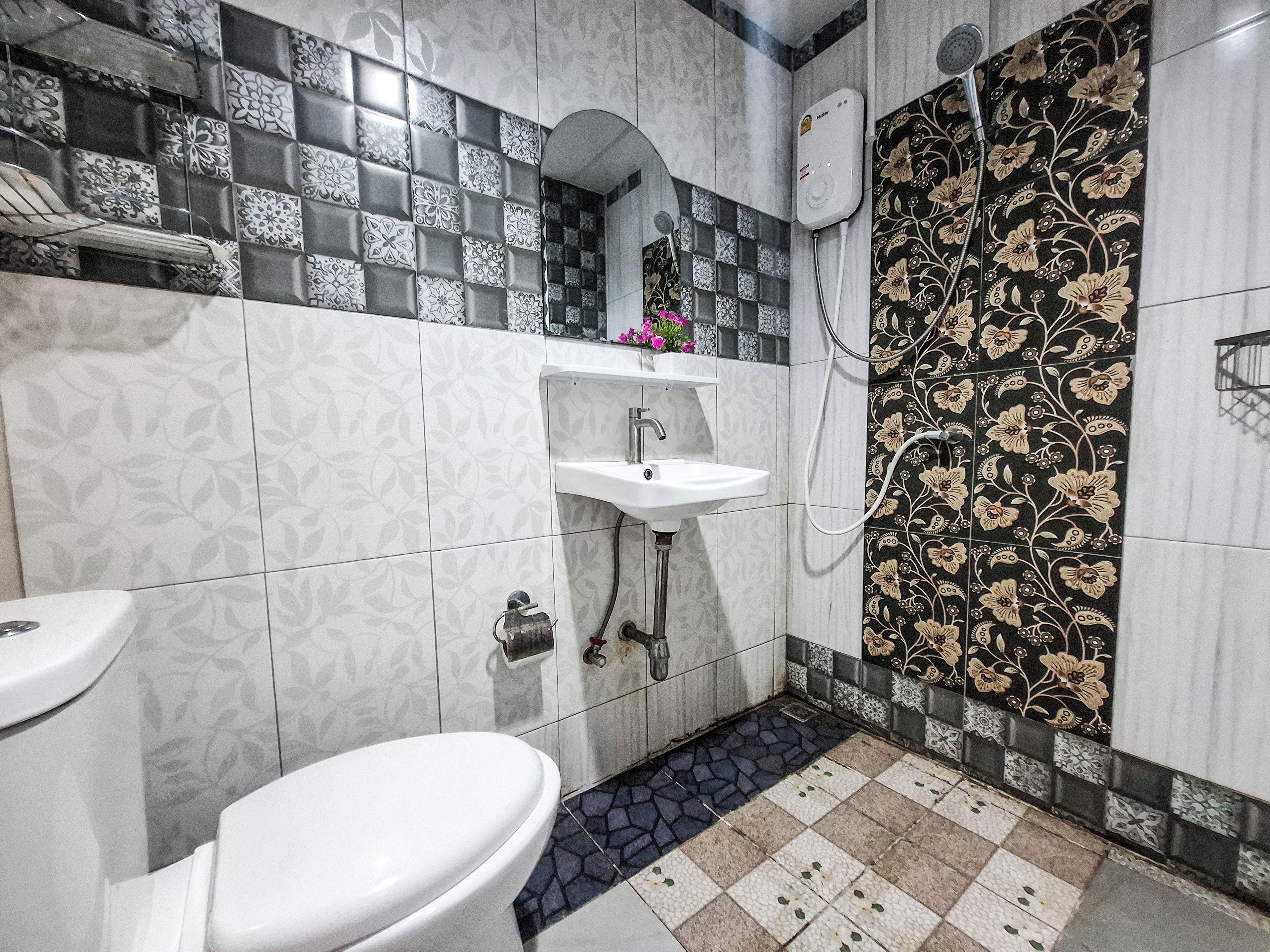A bathroom with a toilet, sink, and shower.