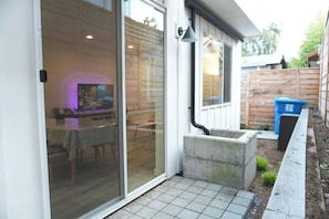 Enter a serene space with a sliding glass door leading to a dining area featuring a table and chairs.